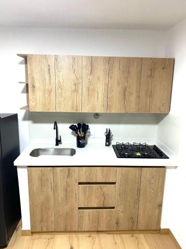 a kitchen with wooden cabinets and a sink at Villa Estadio in Medellín