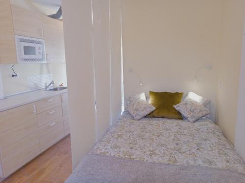 Dormitorio pequeño con cama con almohadas en SANTANDER-LIENCRES VILLA PERAL, en Liencres