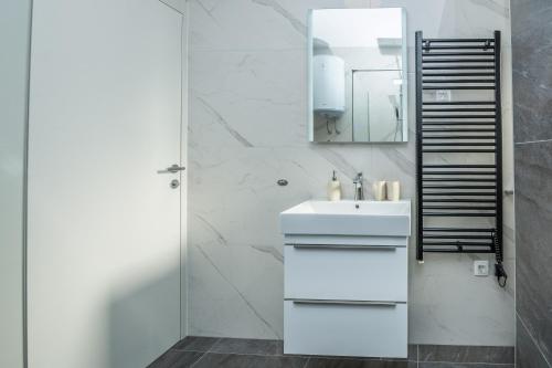 a white bathroom with a sink and a mirror at Seaview apartments Glamour Vir - by TA Leut Agency in Vir