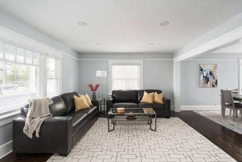 a living room with a black couch and a table at Bankers Hill Chic Roomy Home Near Airport in San Diego