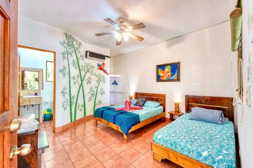 a bedroom with two beds and a ceiling fan at Hotel Tropical Sands Dominical in Dominical