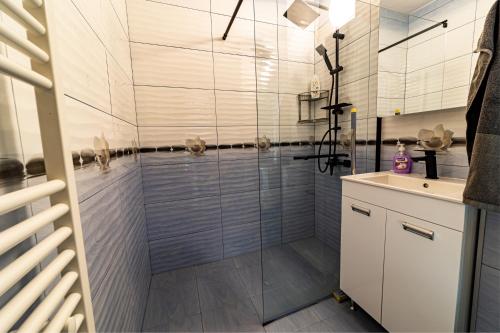 a bathroom with a glass shower with a sink at Nova #7 in Sofia