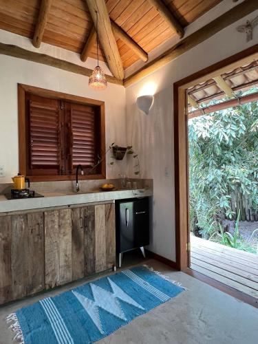 a kitchen with a sink and a large window at VILA IJEXÁ casas e bangalôs CARAÍVA BA in Caraíva