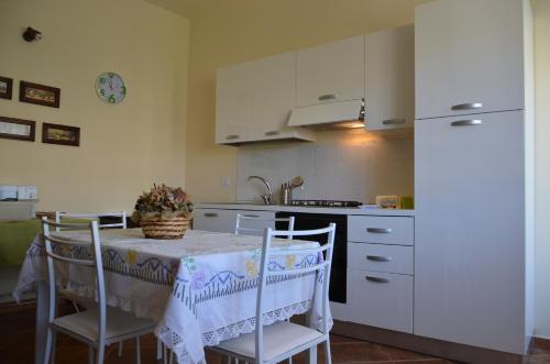 eine Küche mit einem Tisch mit Stühlen und einem Waschbecken in der Unterkunft La Carretteria Guest house in Mistretta