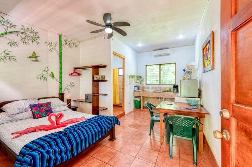 a bedroom with a bed and a table with chairs at Hotel Tropical Sands Dominical in Dominical