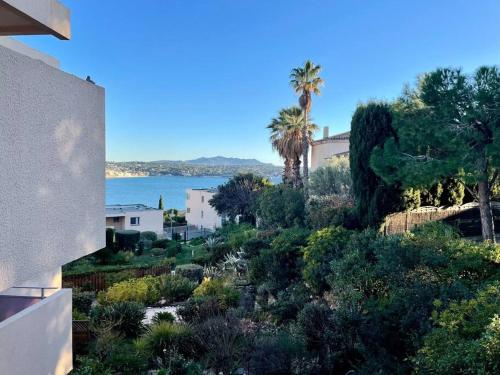 une vue sur l'océan depuis une maison avec des arbres et des buissons dans l'établissement Tout proche de la plage, à 12 min à pied du port, place de parking, à Bandol