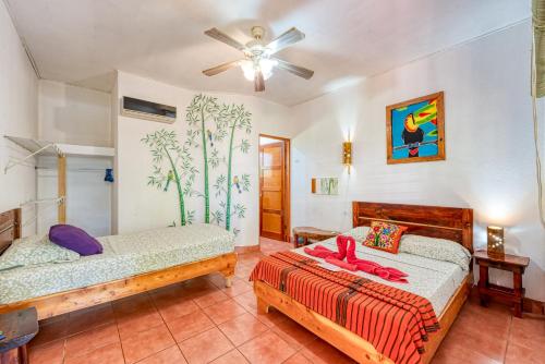a bedroom with two beds and a ceiling fan at Hotel Tropical Sands Dominical in Dominical