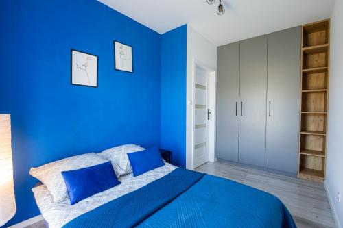 um quarto azul com uma cama com paredes azuis em Vip Apartament Wieniawskiego em Rzeszów