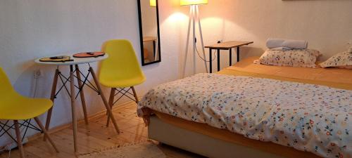 1 dormitorio con 1 cama y 2 sillas amarillas en Lovely place with a view of Skopje, en Skopje