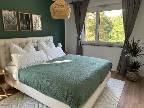 a bedroom with a bed with a green comforter at Ferienwohnung-Parkplatz-Balkon-Küche-Aufzug-SmartTV-Waschtrockner in Erlangen