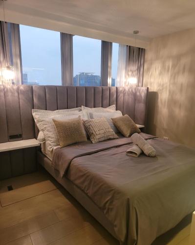 un grande letto in una stanza con una grande finestra di Uptown Parksuites Tower 1 BGC - Staycations Up Above 12 Modern 1BR a Manila