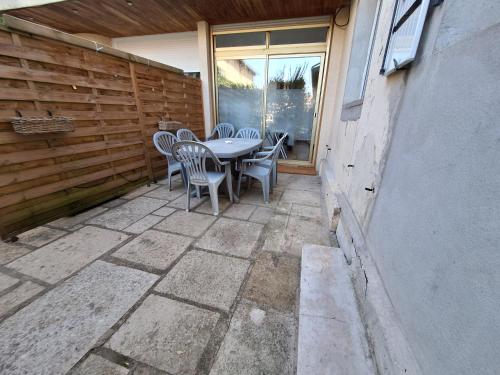 un patio avec une table et des chaises dessus dans l'établissement Le-bon-appart de plain-pied avec terrasse, à Auxonne