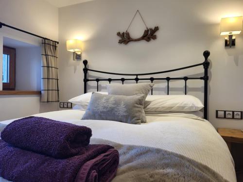a bedroom with a large bed with purple pillows at Couples Gem - Sensational views Nr Morzine in La Côte dʼArbroz