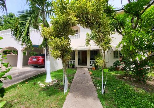 dom z palmami przed podjazdem w obiekcie Green's Palace Jamaica w mieście Oracabessa