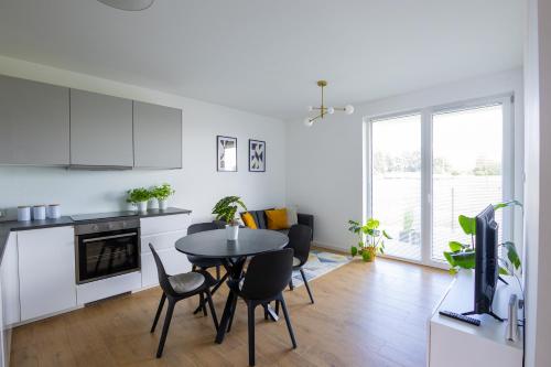 a kitchen and dining room with a table and chairs at Vip Apartamenty in Rzeszów