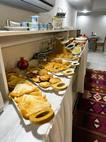 a buffet line with plates of food and pastries at Bobosh Boutique in Bukhara