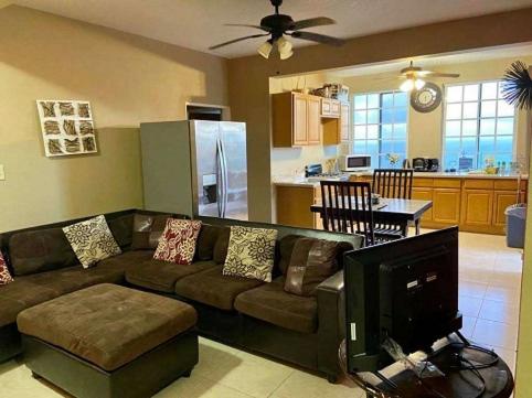 a living room with a couch and a kitchen at SummervilleBVI in Great Mountain