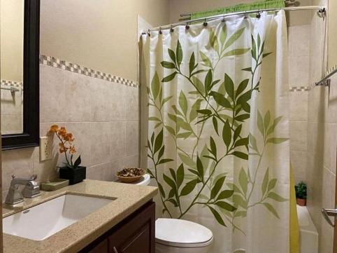 a bathroom with a shower curtain with leaves on it at SummervilleBVI in Great Mountain