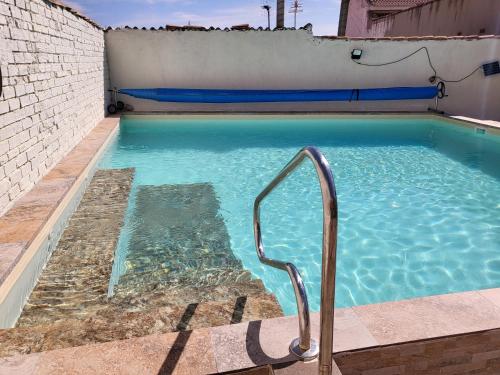 a swimming pool with a hand rail in a building at Casa Oasis Puertollano, una casa rural en Puertollano, agradable, con Piscina en zona tranquila in Puertollano