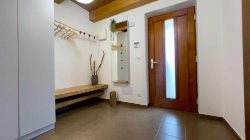 korytarz z drewnianymi drzwiami i ławką w obiekcie Horský apartmán Říčky w mieście Wüstenei