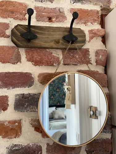 un miroir sur un mur en briques avec un miroir sur celui-ci, dans l'établissement Sigrid & Sea 2 étoiles, Fort-Mahon Plage, à Fort-Mahon-Plage