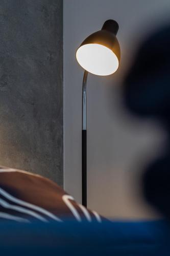 a lamp sitting next to a chair in a room at Vip Apartamenty in Rzeszów