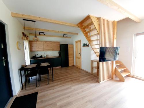 Habitación con mesa, sillas y cocina. en SierPlejs Hill - domek przy szlaku w Górach Sowich, en Sierpnica