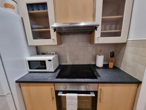 a small kitchen with a stove and a microwave at Make yourself at home! 34AA in Headingley