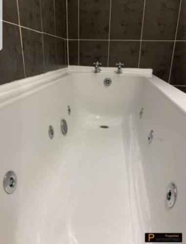 a white bath tub in a bathroom at Make yourself at home! Large Rooms, Comfy in Headingley