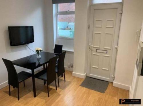 a dining room with a table and chairs and a television at Make yourself at home! 34AA in Headingley