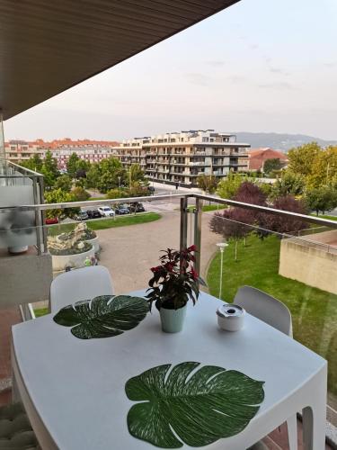 une table blanche avec des plantes sur un balcon dans l'établissement VUT PORTONOVO 2 DORMITORIOS, à Portonovo