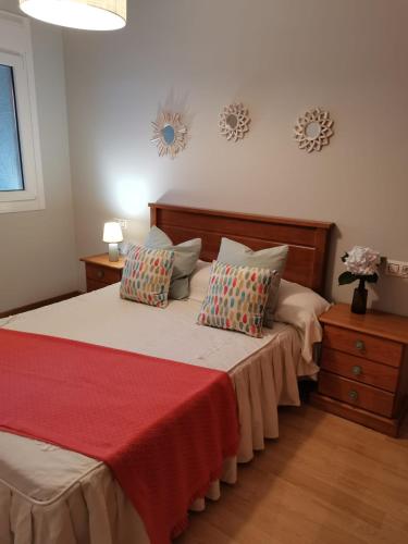 a bedroom with a large bed with a red blanket at VUT PORTONOVO 2 DORMITORIOS in Portonovo