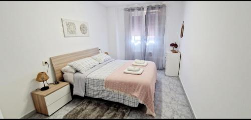 a bedroom with a bed with two towels on it at Apartamento Casa Tambo, Campelo in Pontevedra