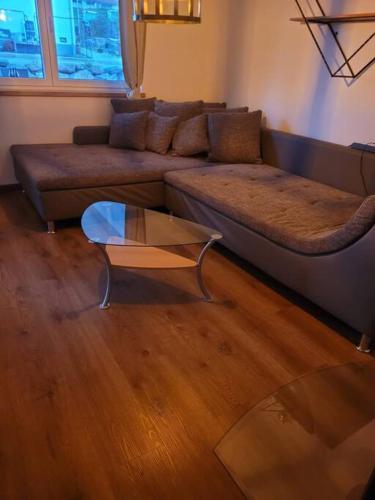 sala de estar con sofá y mesa de cristal en Ferienwohnung Häring en Aitrang