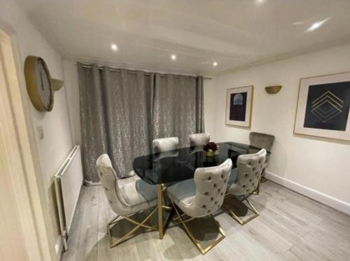 a dining room with a black table and white chairs at Cheshunt Hertfordshire 4 bed in Cheshunt