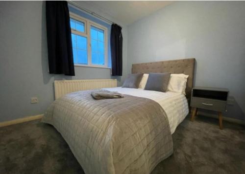 a bedroom with a bed and a window at Cheshunt Hertfordshire 4 bed in Cheshunt