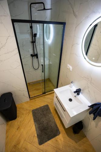 a bathroom with a sink and a shower at Vip Apartamenty in Rzeszów