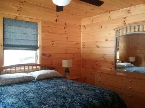 een slaapkamer met een bed in een blokhut bij Timber Bend Retreat in Evart