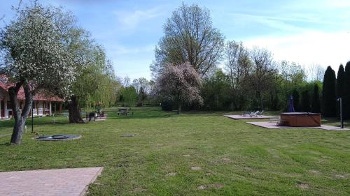 a park with benches and a picnic table in the grass at Almafás Jakuzzis Vendégház Őrség in Kerkakutas