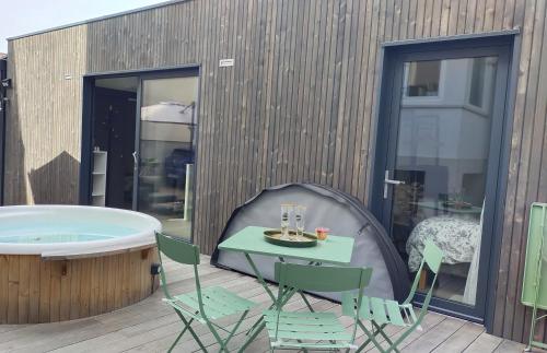 a patio with a table and chairs and a tub at Chez Cathy et Denis in Lingolsheim