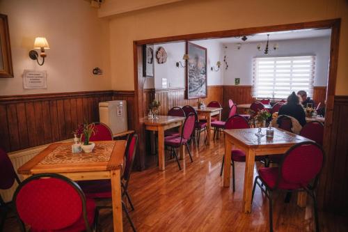 um restaurante com mesas e cadeiras de madeira e pessoas sentadas a mesas em Hostal Hielo Sur em Punta Arenas