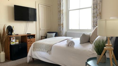 a bedroom with a bed with a television on the wall at Townhouse II in Plymouth