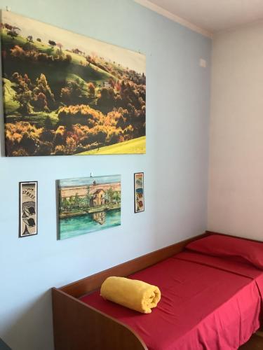 Un dormitorio con una cama roja y una pintura en la pared en EDYSHOME en Peschiera del Garda