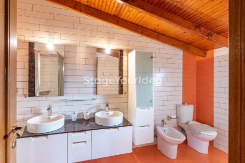 a bathroom with two sinks and a toilet at Luxury appartment, only 7 minutes from Thessaloniki airport and 15 minutes from city center ,for 8-23 people also for gatherings and parties in Néon Rýsion
