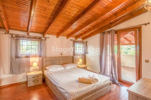 - une chambre avec un lit et un plafond en bois dans l'établissement Luxury appartment 10 minutes from Thessaloniki ,for 8-23 people and gatherings, à Néon Rýsion