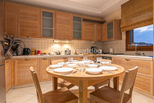 a wooden kitchen with a wooden table and chairs at Luxury appartment, only 7 minutes from Thessaloniki airport and 15 minutes from city center ,for 8-23 people also for gatherings and parties in Néon Rýsion