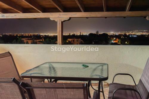 a table and chairs on a balcony at night at Luxury appartment, only 7 minutes from Thessaloniki airport and 15 minutes from city center ,for 8-23 people also for gatherings and parties in Néon Rýsion