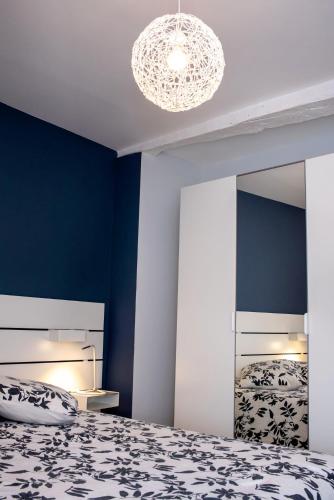 une chambre avec un lit et un grand miroir dans l'établissement Au Coeur du Village Bassillac Périgueux, à Bassillac