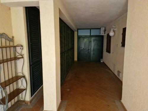 a hallway with a green door in a building at Frontemare in Porto Santo Stefano