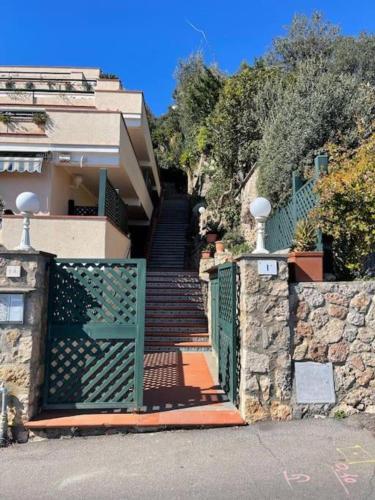a stairway leading to a house with a green gate at Frontemare in Porto Santo Stefano